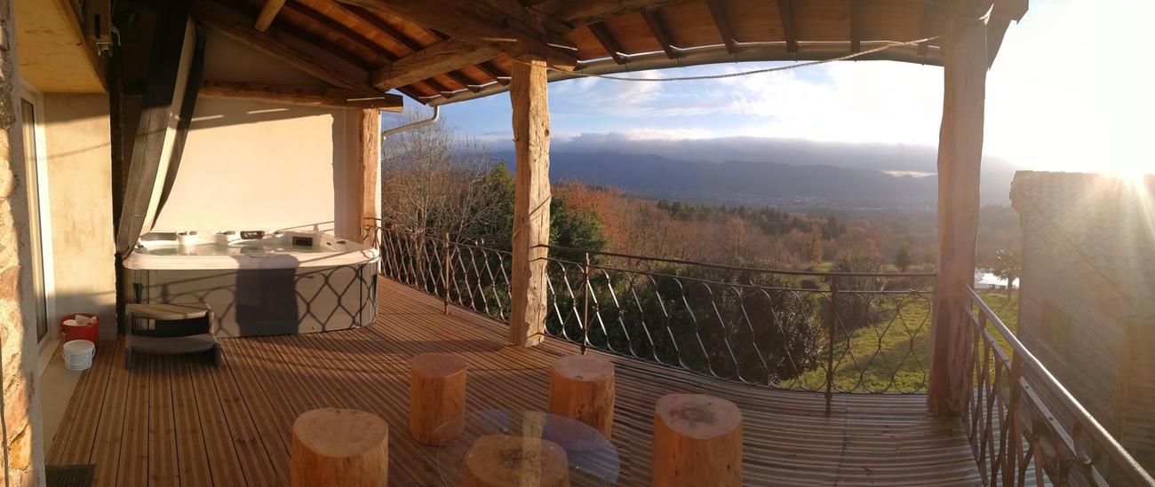Terraza cubierta con salón y spa sobre el valle