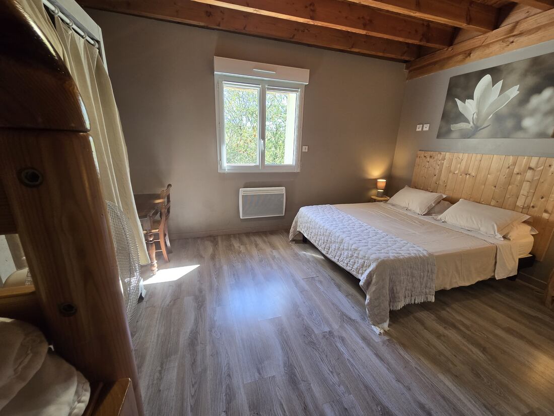 Habitación con cama de matrimonio, litera y escritorio