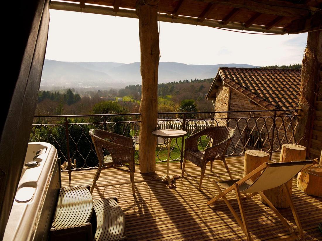 La terraza cubierta superior con el spa, los sillones de mimbre y las vistas